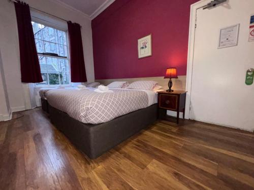 a bedroom with a bed and a table with a lamp at Regent House Hotel - City Centre Hotel in Edinburgh