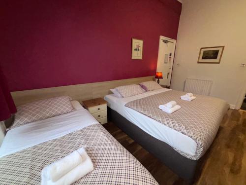 two beds in a room with purple walls at Regent House Hotel - City Centre Hotel in Edinburgh