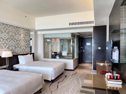 a hotel room with two beds and a bathroom at Swiss Grand Xiamen-Harbour View in Xiamen