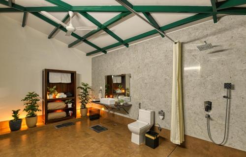 a bathroom with a shower and a toilet and a sink at Sukoon - A Wellness Resort, Uttarakhand in Chūharpur