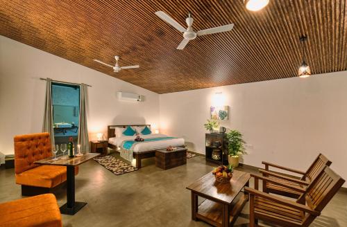 a bedroom with a bed and a living room at Sukoon - A Wellness Resort, Uttarakhand in Chūharpur