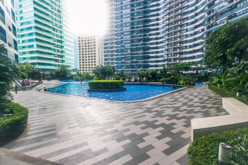 a pool in the middle of a city with tall buildings at Witty Weekend retreat Quirk Cozy in Manila