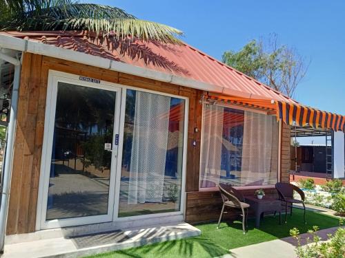 a house with sliding glass doors and a table and chairs at Chan Beach Resort & Hotel in Bahūr