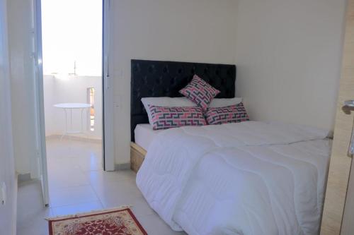 a bedroom with a bed with two pillows on it at Appartement vue panoramique sur mer Avec Climatisation! à 5 minutes à pied de la Plage ! à environ 6 minutes en voiture du Centre d'Agadir et à 10 minutes en voiture de Taghazout ! in Agadir