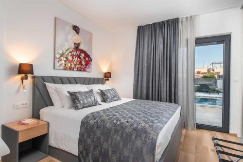 a bedroom with a bed and a large window at Luxury Villa Heated Pool, 6 persons, Jacuzzi, Sea View in Zaglavice