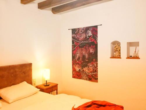 a bedroom with a bed and a painting on the wall at Spatieux, confort, reposant, gd jardin bucolique, jeux, balades, zoo, châteaux in Saint-Romain-sur-Cher