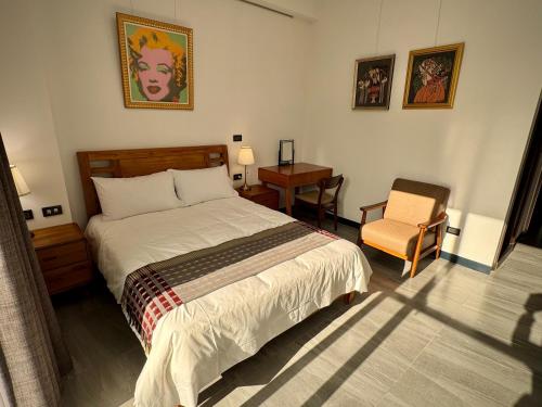 a bedroom with a large bed and a chair at P and B's Home in San-k'un-shen