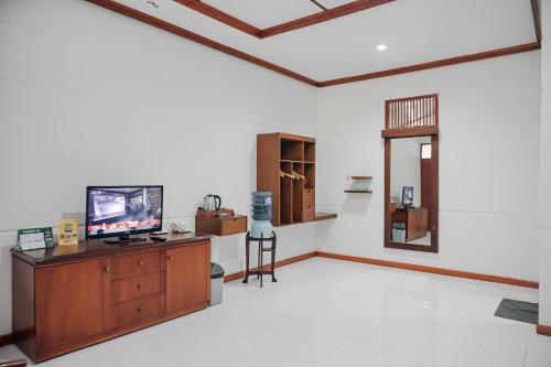 a living room with a tv on a wooden cabinet at Lembah Ciater Resort Managed by Sahid in Ciater