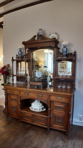 an old wooden dresser with a mirror and a table at Repos à Ribérac B&B in Ribérac