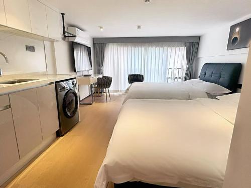 a hotel room with two beds and a kitchen at Mihua International Apartment - Guangzhou Yangang Subway Station Branch in Guangzhou