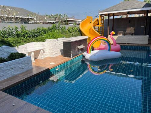 a swimming pool with a slide at Hua Hin Pool Villa and Pool table with 3 bedrooms, 3 bathrooms near Cha-Am beach in Nikhom Sang Ton Eng Khuan Phet