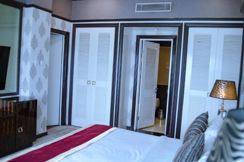 a bedroom with a bed and some shuttered windows at Sutanraja Hotel & Convention Centre in Soreang
