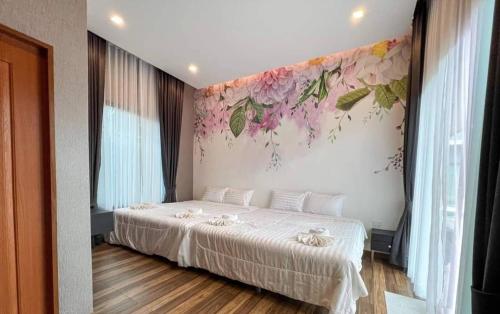 a bedroom with a bed with a flower mural on the wall at Hua Hin Pool Villa and Pool table with 3 bedrooms, 3 bathrooms near Cha-Am beach in Nikhom Sang Ton Eng Khuan Phet