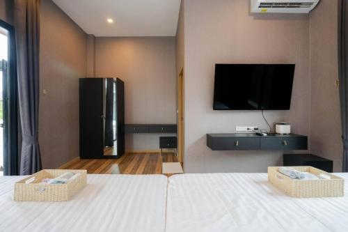 a bedroom with a large bed with a tv on the wall at Hua Hin Pool Villa and Pool table with 3 bedrooms, 3 bathrooms near Cha-Am beach in Nikhom Sang Ton Eng Khuan Phet