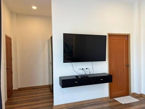 a living room with a television on a wall at Hua Hin Pool Villa and Pool table with 3 bedrooms, 3 bathrooms near Cha-Am beach in Nikhom Sang Ton Eng Khuan Phet