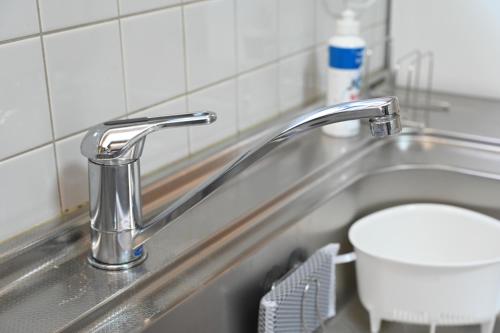 a bathroom sink with a toilet and a faucet at Bhome Hikone Jizo in Hikone