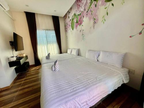 a bedroom with a large white bed with flowers on the wall at Hua Hin Pool Villa and Pool table with 3 bedrooms, 3 bathrooms near Cha-Am beach in Nikhom Sang Ton Eng Khuan Phet