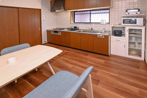 a kitchen with a table and a table and chairs at Bhome Hikone Jizo in Hikone