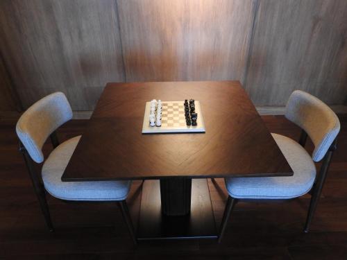a chess board on a wooden table with two chairs at Taj Guras Kutir Resort & Spa, Gangtok in Gangtok