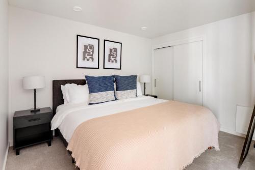 a white bedroom with a large bed with blue pillows at Soma 1br w pool gym nr transport SFO-1475 in San Francisco