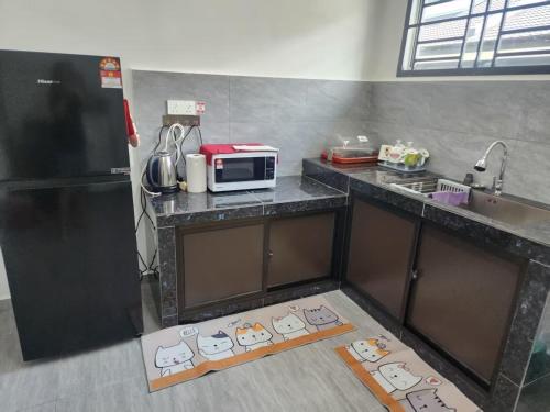 a kitchen with a counter with a microwave on it at SW Homestay KOTA TINGGI 2 in Kota Tinggi