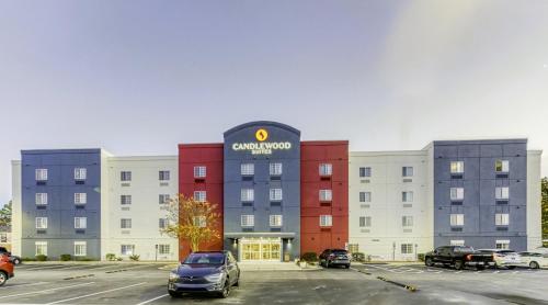 a rendering of an apartment building with cars parked in a parking lot at Candlewood Suites New Bern by IHG in New Bern