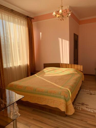 a bedroom with a bed and a chandelier at Гостевой дом "Светлана" in Cholpon-Ata