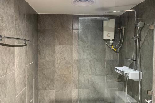 a bathroom with a shower and a sink at Hotel Kaya Puerto Galera in Sabang
