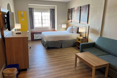 a hotel room with a bed and a couch at Days Inn by Wyndham near Kansas Speedway in Kansas City