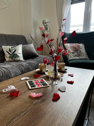 a table with a vase with red roses on it at Angelina Art in Trnava