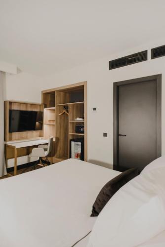 a bedroom with a bed and a desk and a table at Hotel Dimar in Valencia