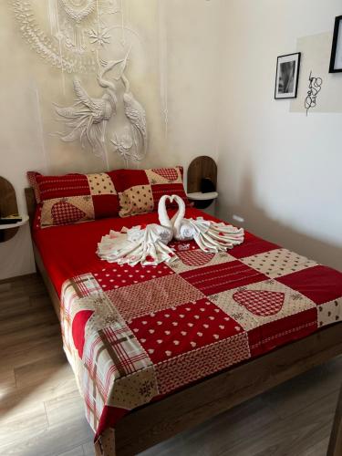 a bed with a red and white quilt on it at Angelina Art in Trnava