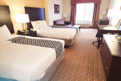 a hotel room with two beds and a desk at La Quinta by Wyndham Stillwater -University Area in Stillwater