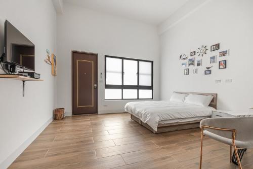 a white bedroom with a bed and a window at Xiao San Chill in Xiaoliuqiu