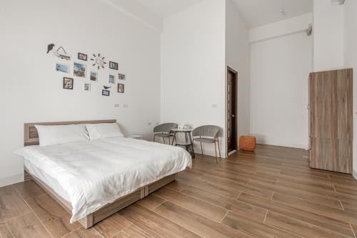 a bedroom with a bed and a table with chairs at Xiao San Chill in Xiaoliuqiu