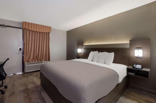 a hotel room with a large bed and a window at Quality Inn Fort Jackson in Columbia