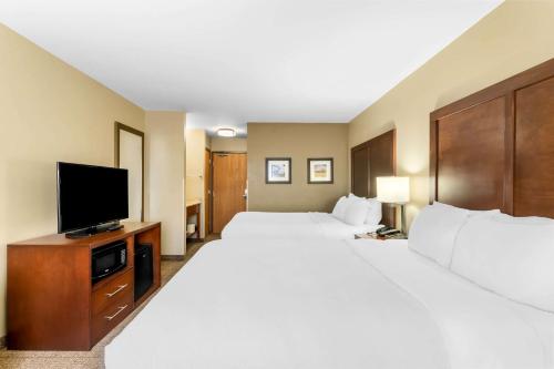 a hotel room with two beds and a flat screen tv at Comfort Inn & Suites Near University of Wyoming in Laramie