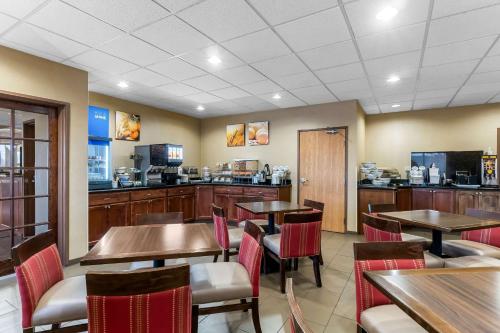 a restaurant with tables and chairs and a kitchen at Comfort Inn & Suites Near University of Wyoming in Laramie