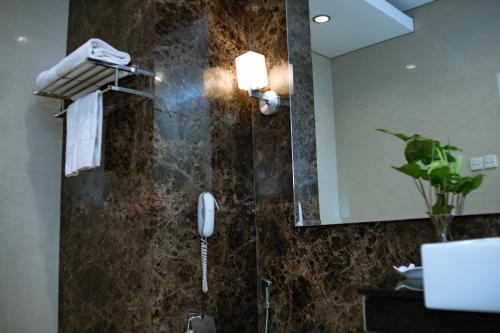 a bathroom with a shower with a phone in it at Sutanraja Hotel & Convention Centre in Soreang