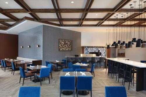 a dining room with blue chairs and tables at Doubletree By Hilton Battle Creek in Battle Creek