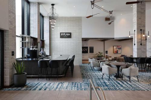 a restaurant with tables and chairs and a bar at Doubletree By Hilton Battle Creek in Battle Creek