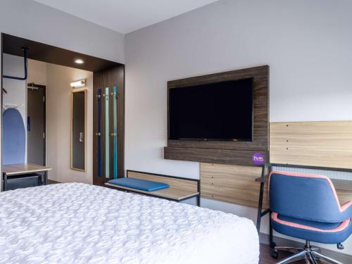 a bedroom with a bed and a flat screen tv at Tru By Hilton Chesapeake- Greenbrier in Chesapeake