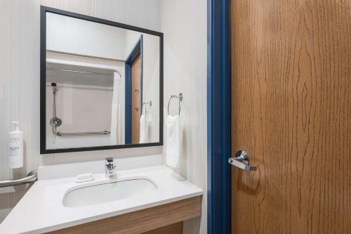 a bathroom with a sink and a mirror at Spark by Hilton Dumas in Dumas