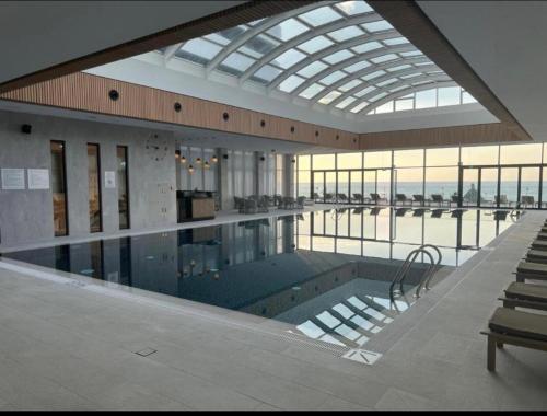 una grande piscina in un edificio con soffitto in vetro di BATUMI PALACE Resort a Batumi