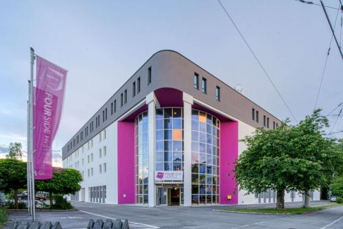 a pink and white building on a street at FourSide Hotel Salzburg Messe, Trademark Collection by Wyndham in Salzburg