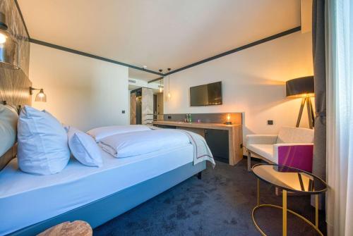 a hotel room with a bed and a desk at FourSide Hotel Salzburg Messe, Trademark Collection by Wyndham in Salzburg