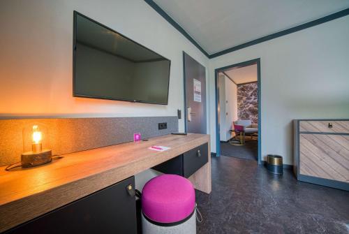 a room with a large flat screen tv on a wall at FourSide Hotel Salzburg Messe, Trademark Collection by Wyndham in Salzburg