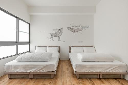 two beds in a room with white walls at Xiao San Chill in Xiaoliuqiu