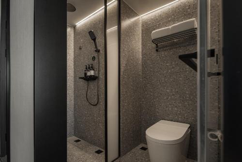 a bathroom with a toilet and a shower at 欢桔酒店 郑州二七广场丹尼斯大卫城店 in Zhengzhou