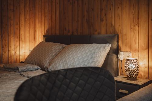 a bedroom with a bed and a wooden wall at Villa Apartman in Makó